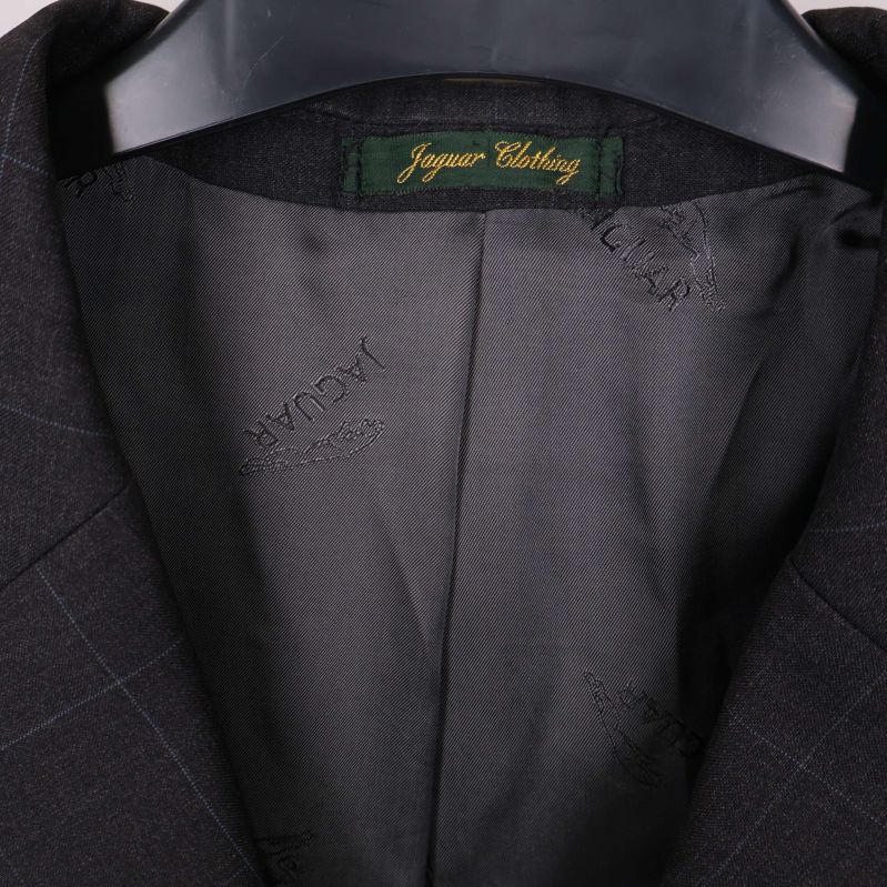Närbild på grön etikett med märket Jaguar Clothing i kavajens krage