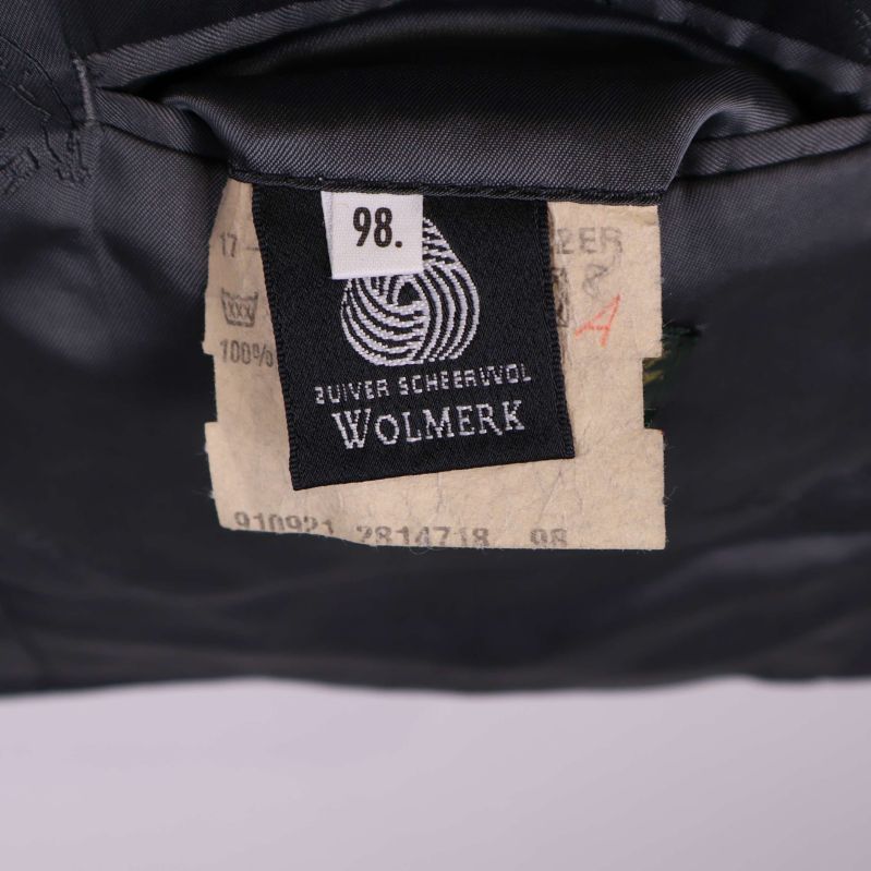 Material- och storleksetikett med texten Wolmerk och 98
