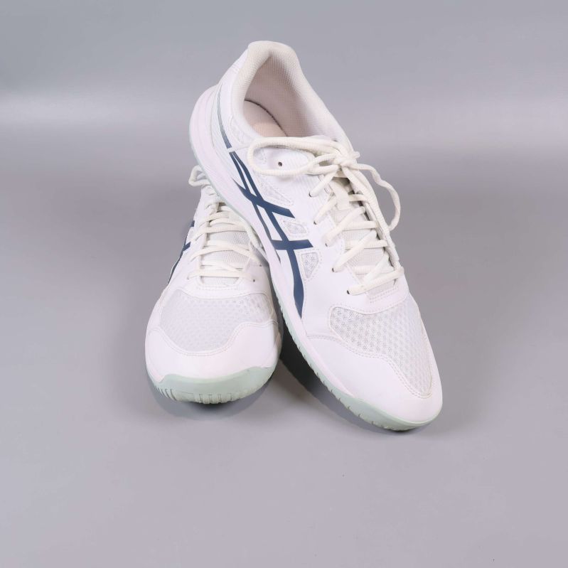 Vita sneakers poserar mot varandra i studioljus