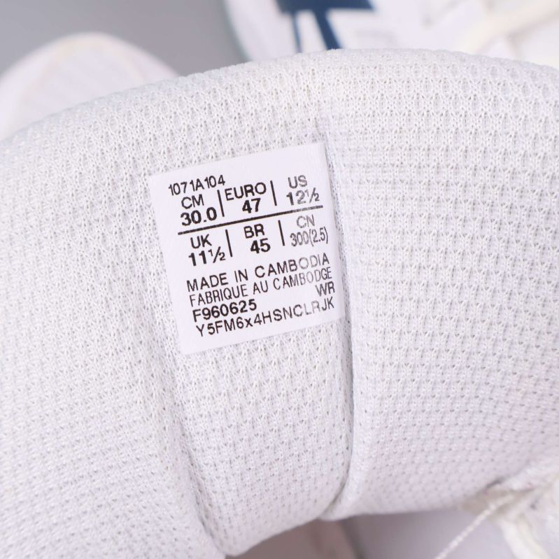 Närbild på storlekslapp inuti vita sneakers