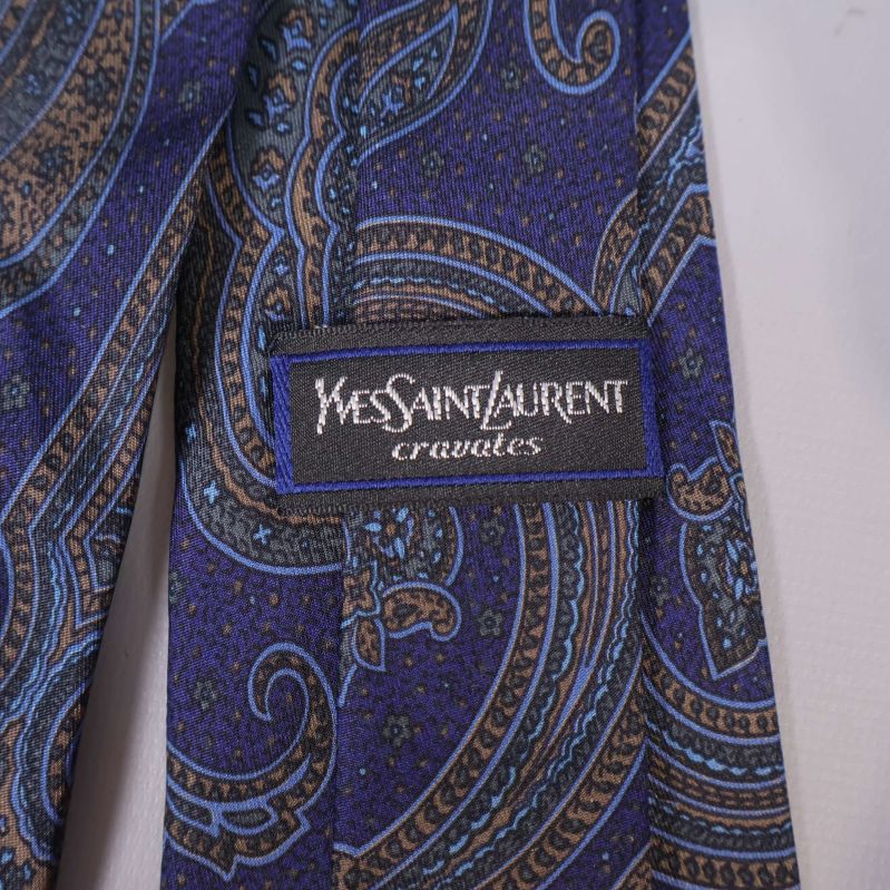 Närbild på Yves Saint Laurent-logga på slips