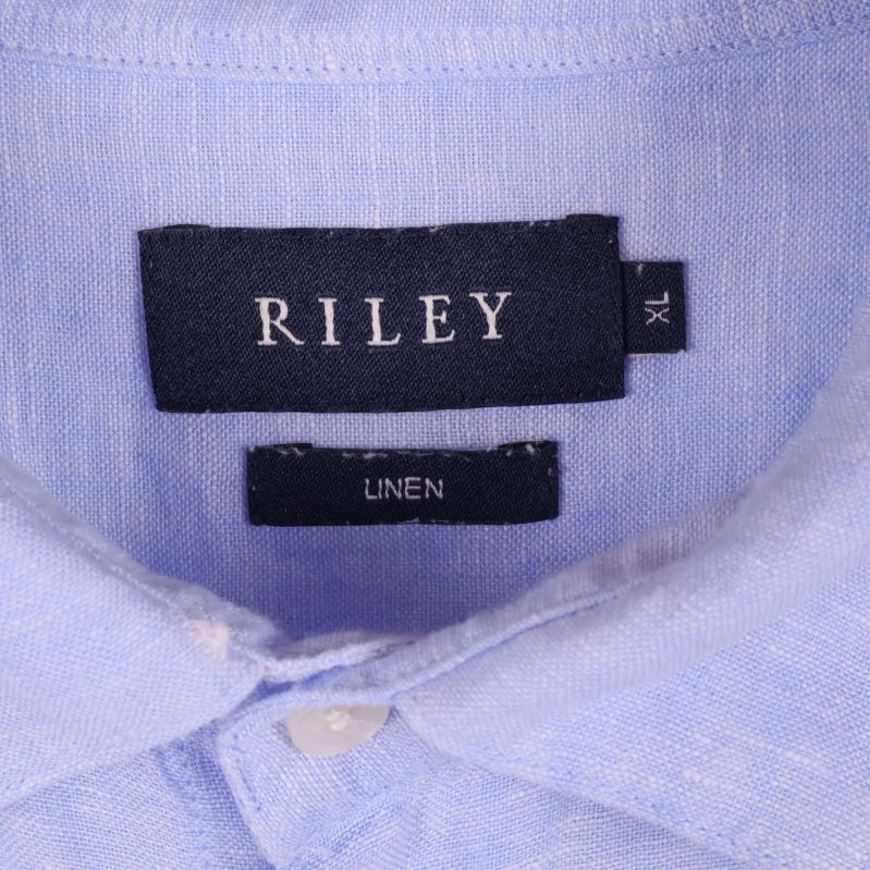 Närbild på etikett med varumärket Riley och linnematerial