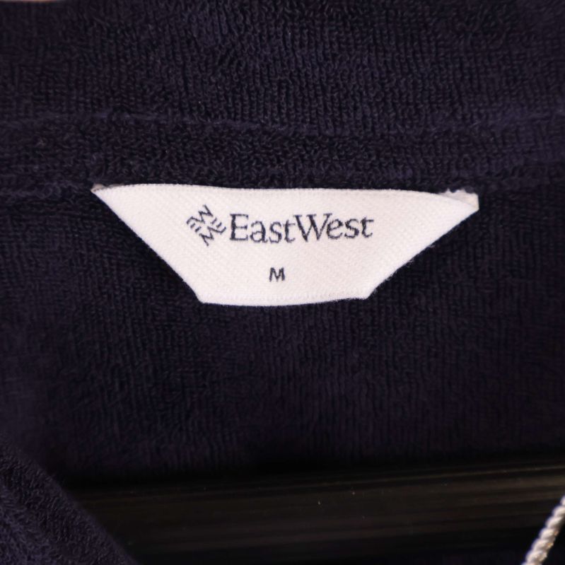 Närbild på etikett med EastWest och storlek M