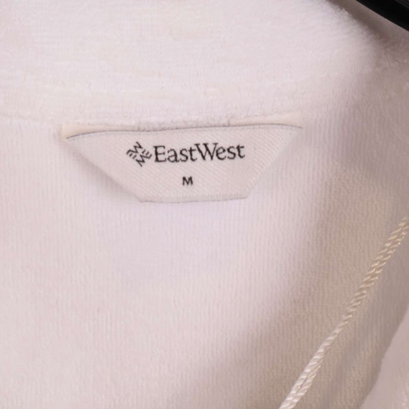 Närbild av etikett med texten EastWest och storlek M