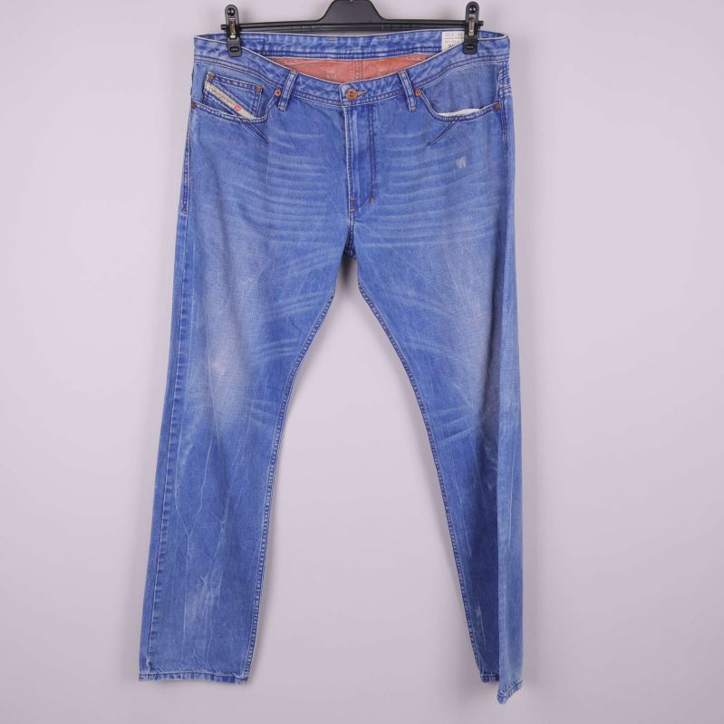Framsidan av blå slitna slim jeans på galge