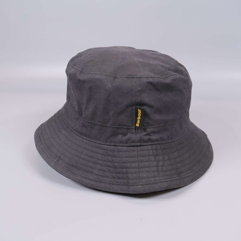 Sida av bucket hat med Barbour-etikett i gult