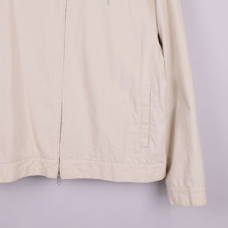 Midje- och ärmdetaljer på beige jacka 