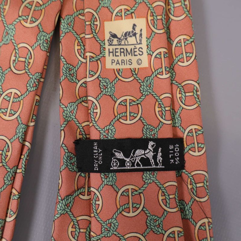 Närbild på Hermès-slipsen med materialetikett i svart
