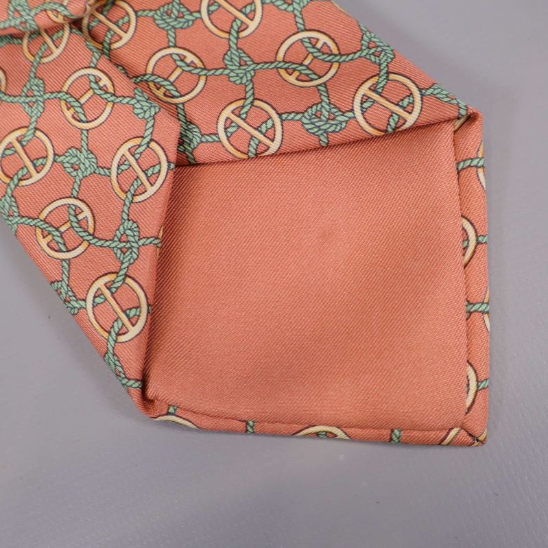 Detalj på spetsen av aprikosfärgad Hermès-slips