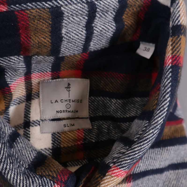 Närbild på etikett med La Chemise Norrmalm och storlek 38