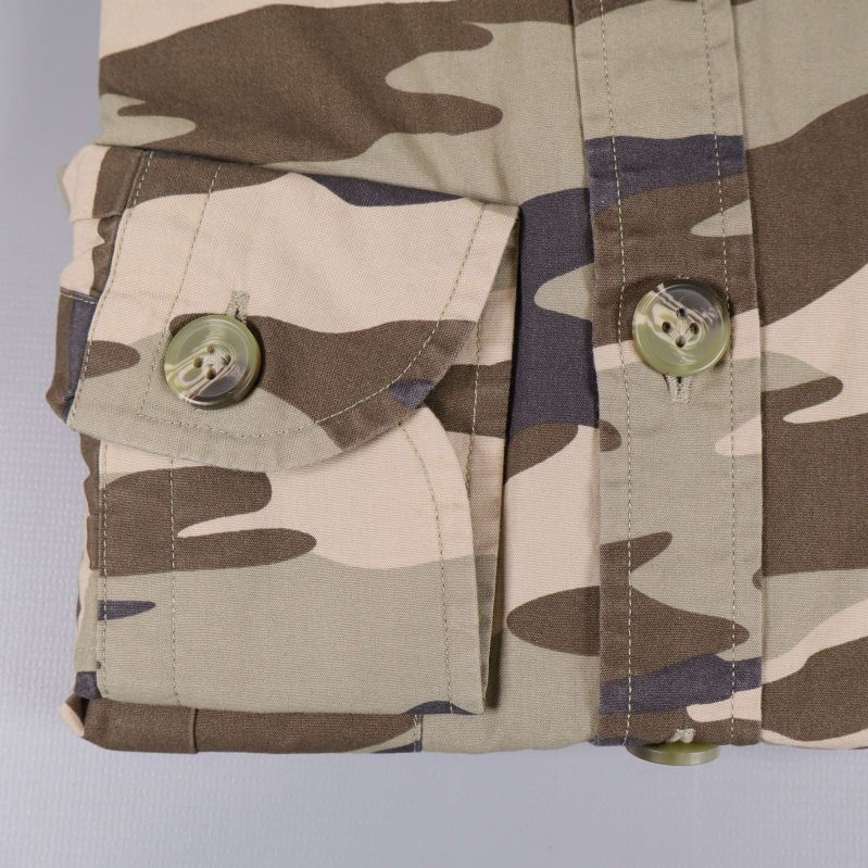Närbild på manschett och knapp med camouflagemönster