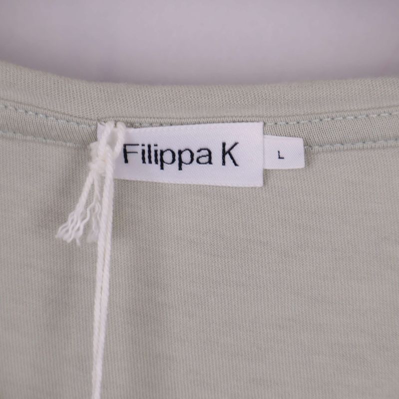 Närbild på halsringning med Filippa K etikett och storlek L