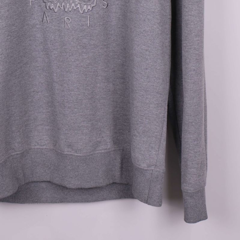 Ribbad mudd i ärmslut och nederkant av grå sweatshirt