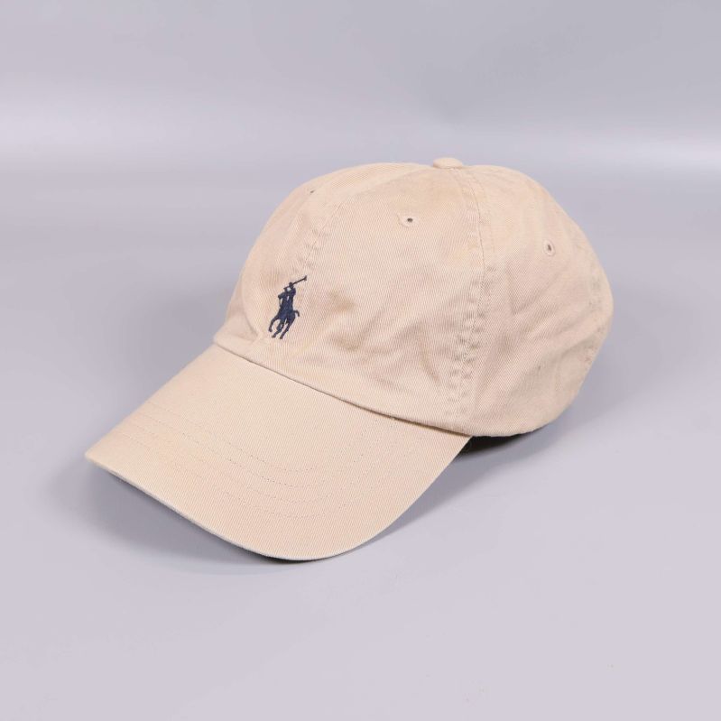 Beige keps med blå broderad logga på sidan
