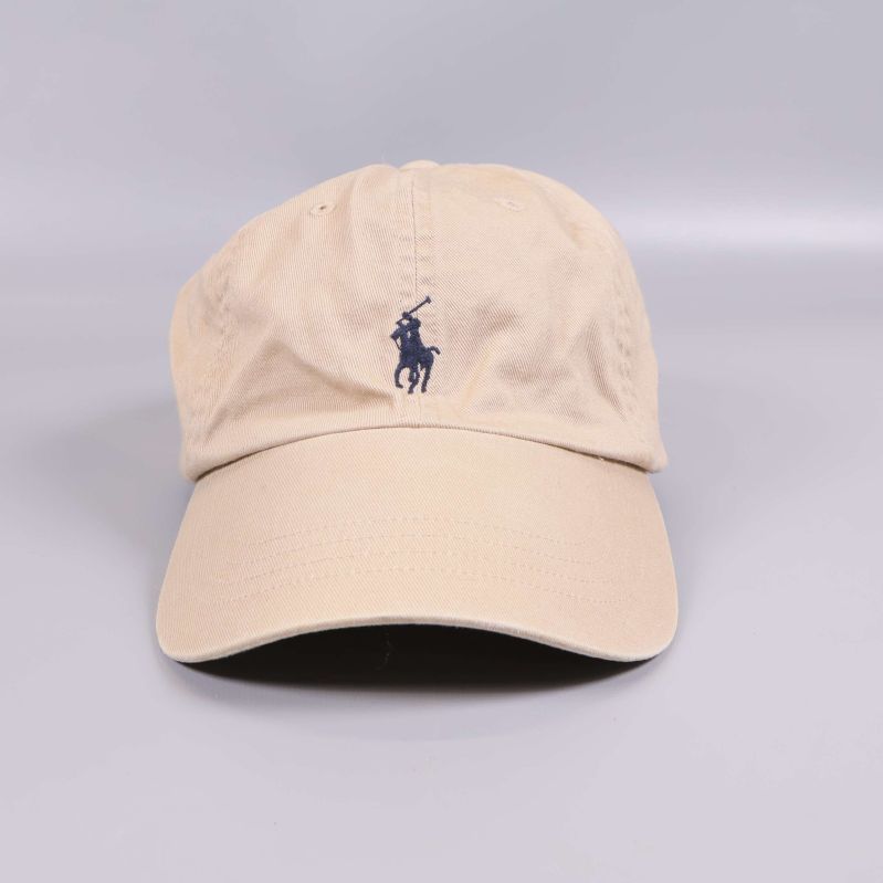 Framsidan av beige keps med blå logga