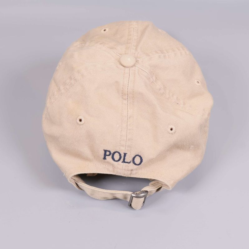 Baksidan av beige keps med justerbar rem och texten POLO