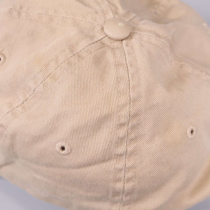 Närbild på tyg och sömmar på beige keps