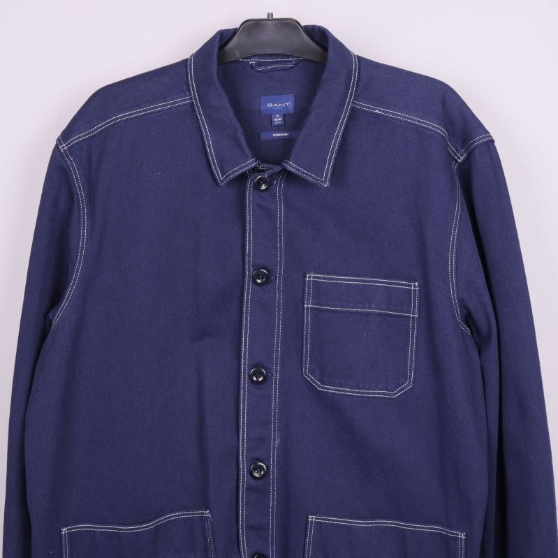 Övre del av mörkblå overshirt med knappdetaljer och bröstficka