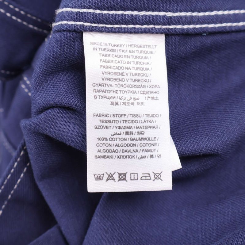 Materiallapp som visar 100% bomull på flera språk