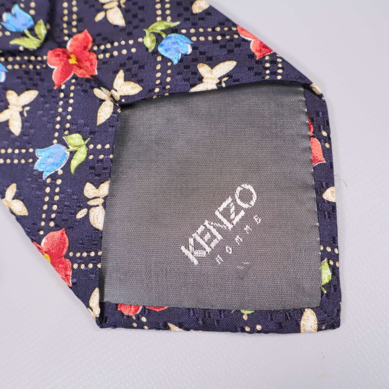 Slipsens spets med broderad Kenzo-logotyp på grå baksida