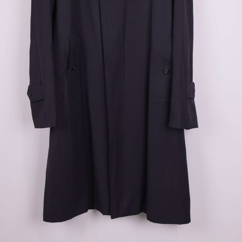 Närbild på ärmslut och fickdetaljer på trenchcoat