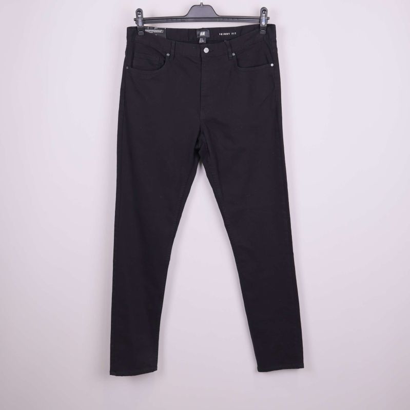Framsidan av svarta skinny jeans på galge