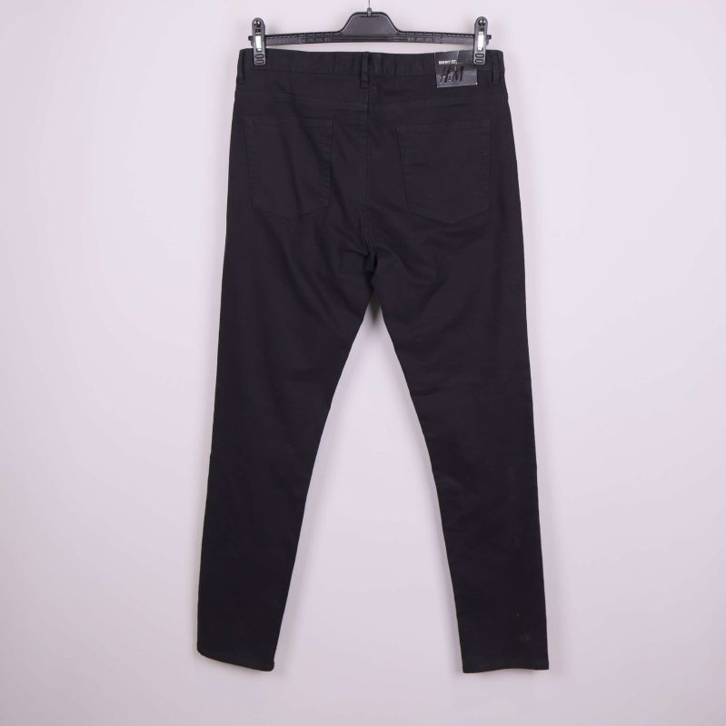 Baksidan av svarta skinny jeans på galge