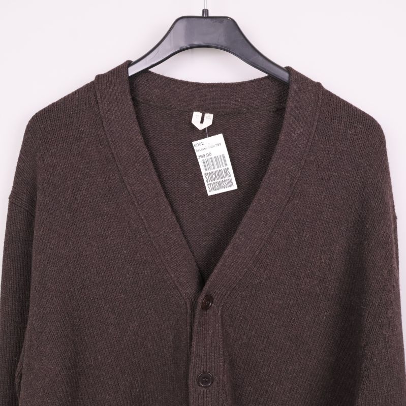Närbild på etikett och halsringning på brun cardigan