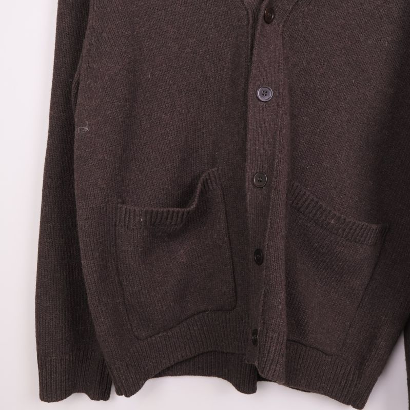 Stickad brun cardigan med fickor och knappar i närbild