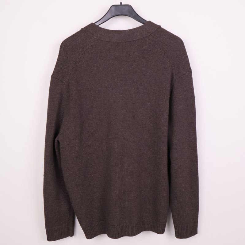 Baksidan av stickad brun cardigan på galge