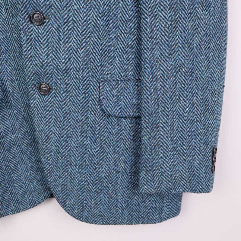 Fickdetalj och ärm på kavajen i blå tweed