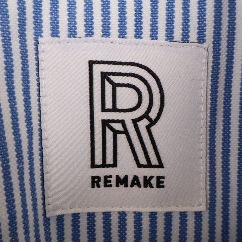 Närbild på Remake-logotyp på skjortan