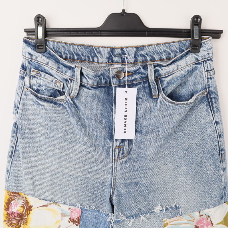 Övre del av patchwork jeans med etikett