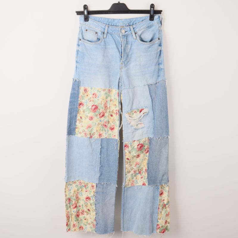 Framsidan av jeans i ljusblå patchwork med blommönster