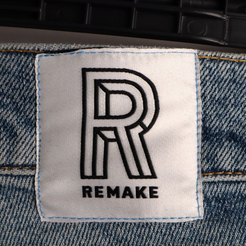 Närbild av Remake-märket på jeansen