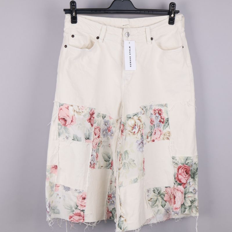 Framsida av vita bermudashorts med blommönster