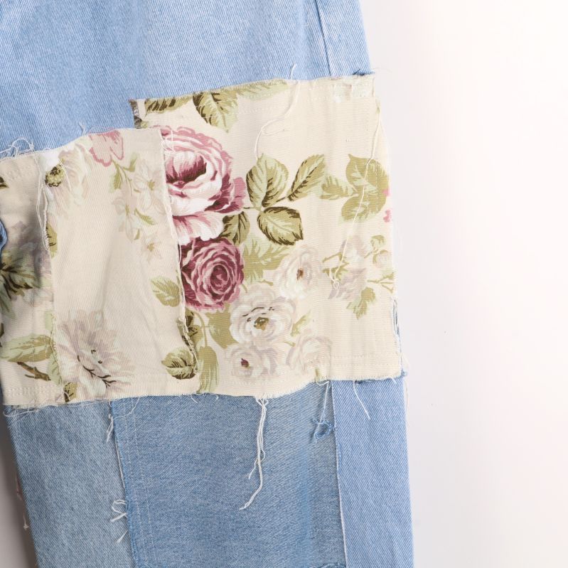 Detalj av blompatch på jeansben