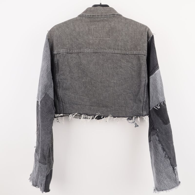 Baksidan av denimjackan med patchar och fransar
