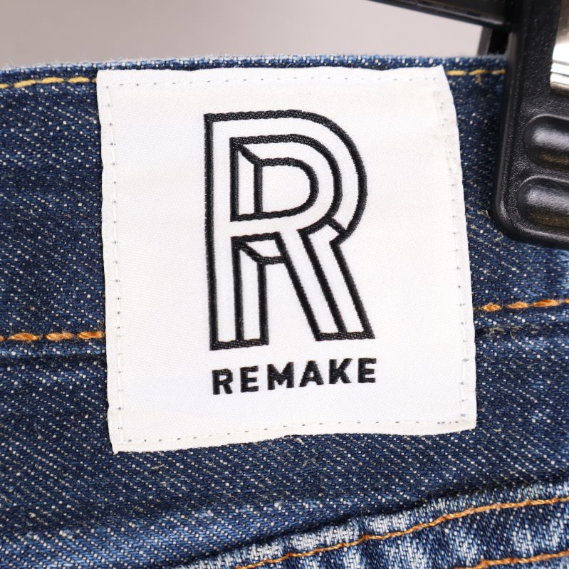 Närbild av Remake-logga på jeans