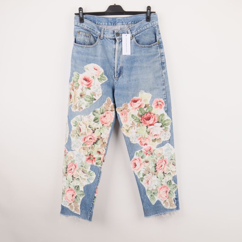 Framsidan av jeans med blommiga patchar