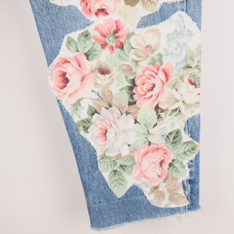 Blommiga patchar på nedre delen av jeans benet