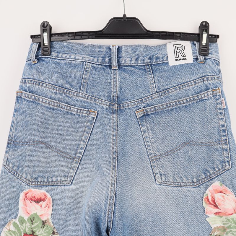 Baksidan av jeans med två fickor och blommiga patchar