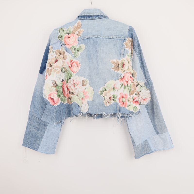 Baksida av denimjacka med patchade blommor