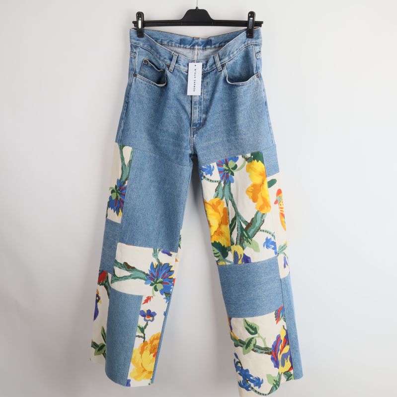 Framsida av jeans med blommiga patchar