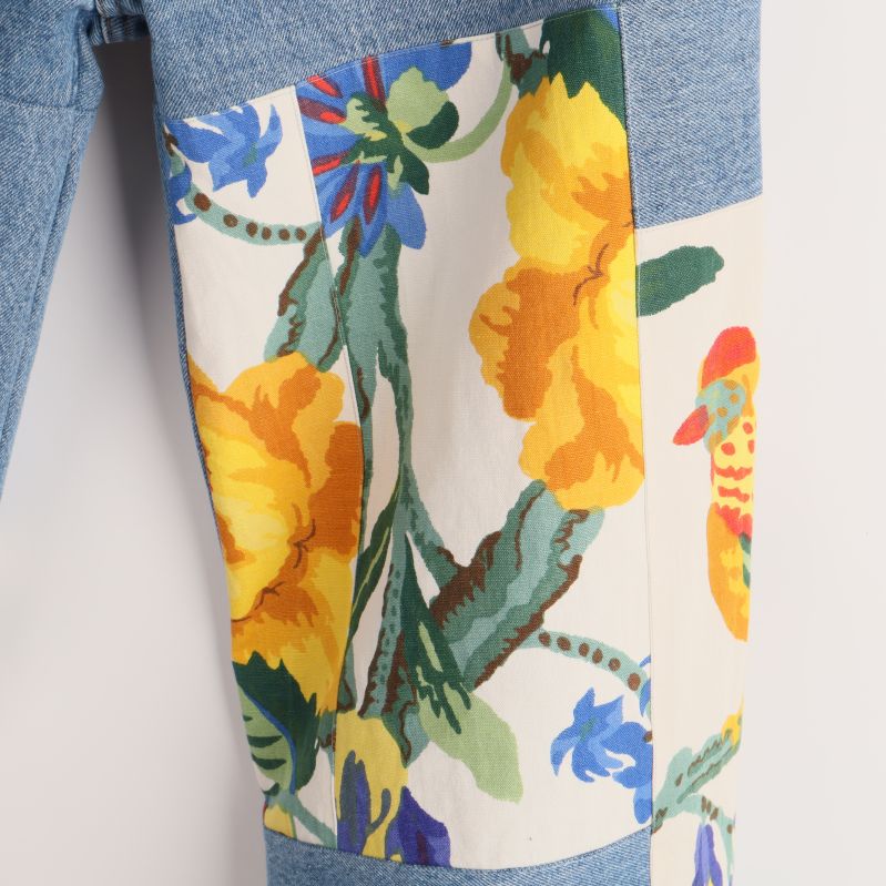 Närbild på blommig detalj på jeansen