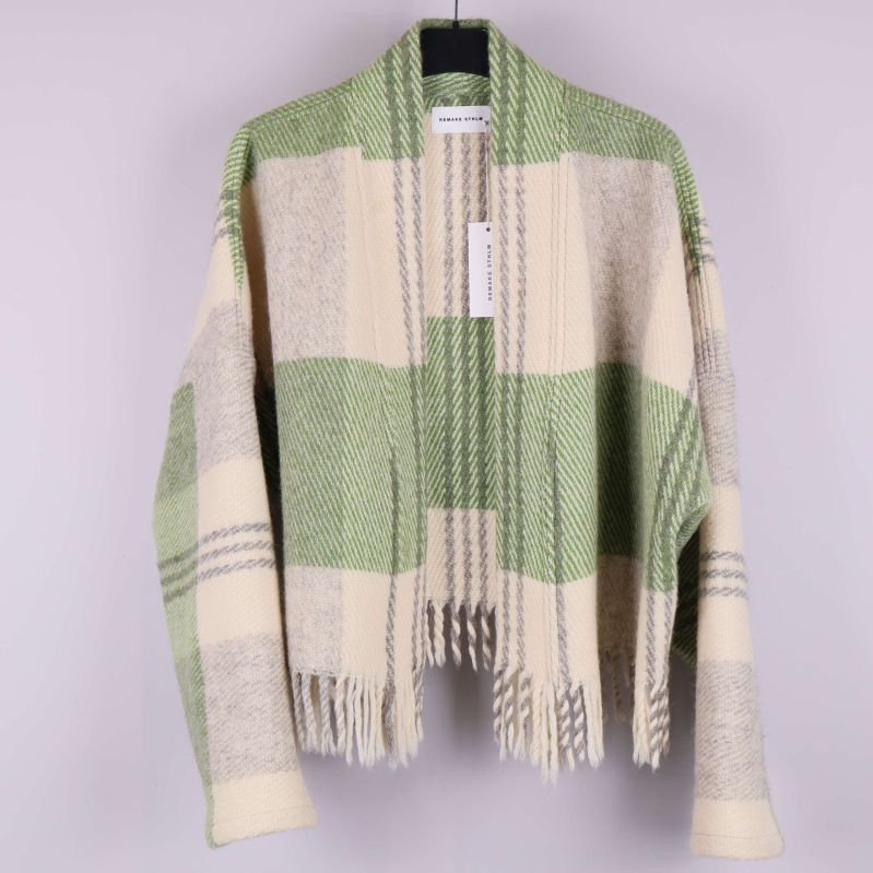 Grön och cremefärgad rutig cardigan hänger på galge