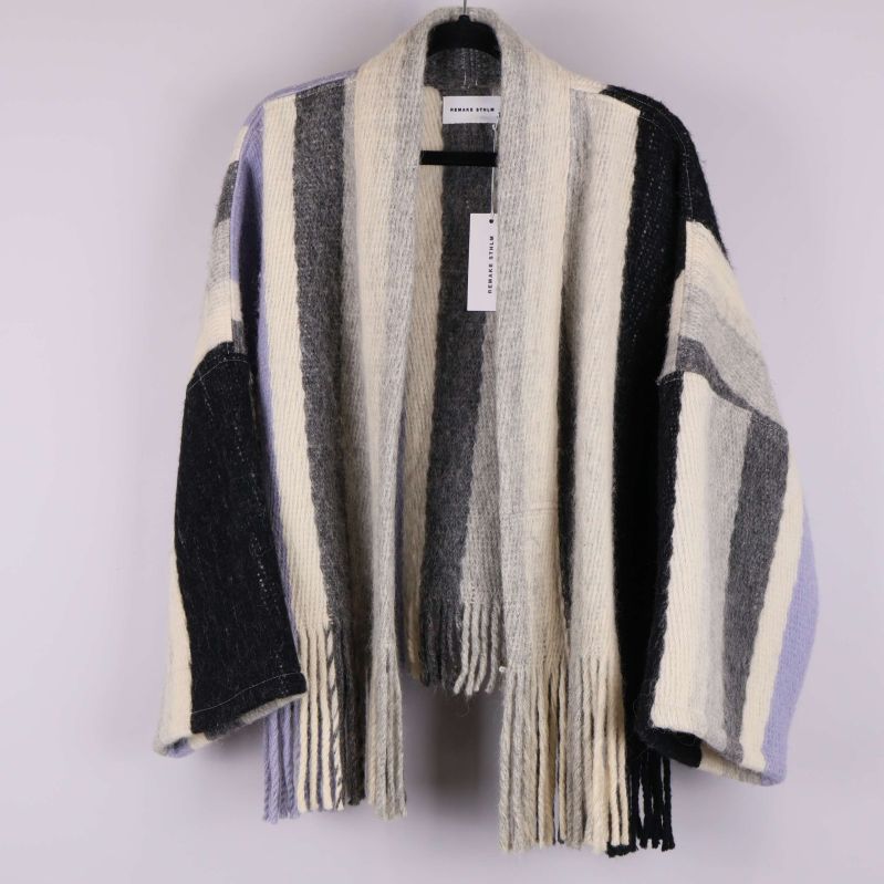 Randig cardigan hänger på galge mot ljus bakgrund