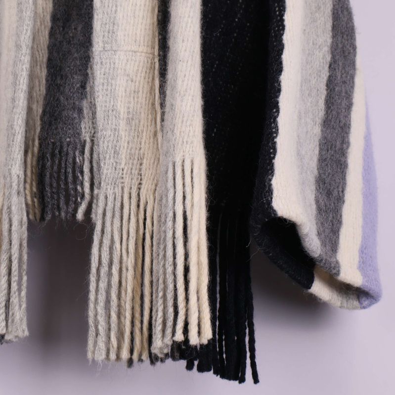 Närbild av fransdetaljer längst ner på cardigan