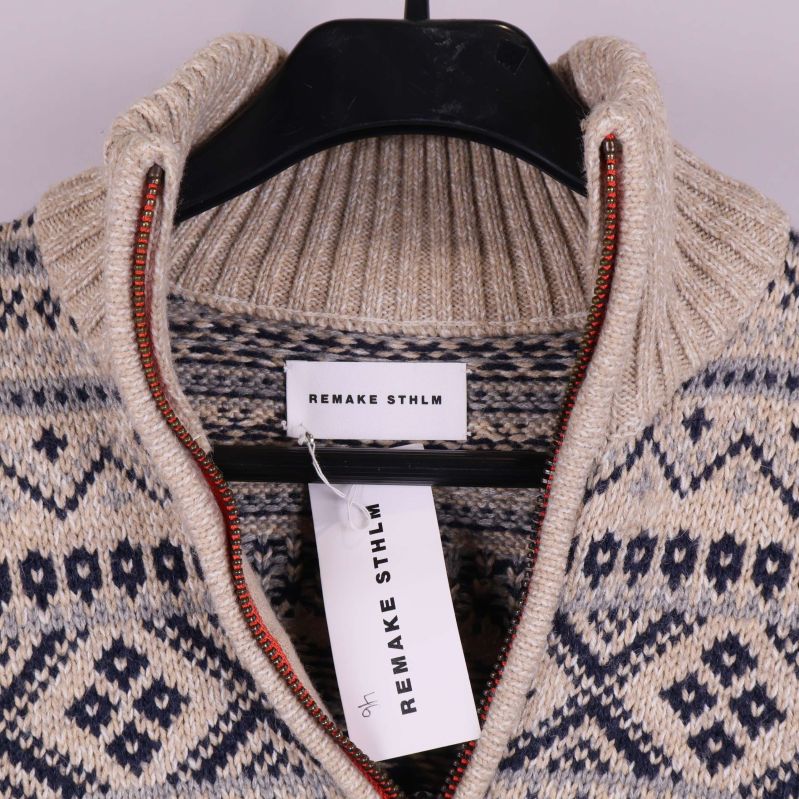 Närbild på halsringning med dragkedja och etikett Remake Sthlm