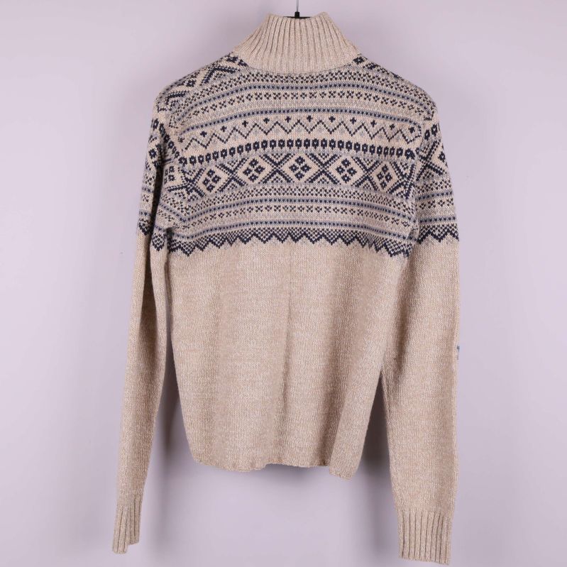 Baksidan av beige stickad tröja med mörkblå mönster